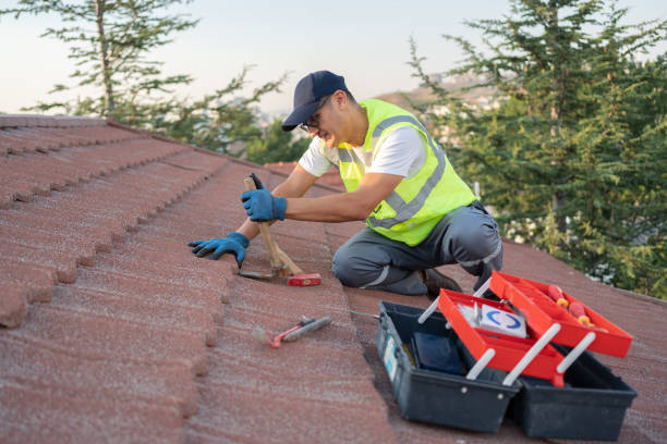 A man wearing a safety vest and work gloves is diligently working on a roof, ensuring safety and precision in his roof repair in Atlanta task.