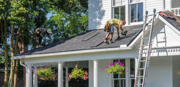 Two men collaborating on the roof of a house, engaged in roof repair in Atlanta, working under clear skies.