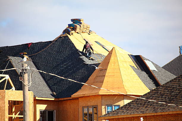Construction workers assembling a new roof in Douglasville, GA, on a building under clear blue skies, ensuring expert roof installation.