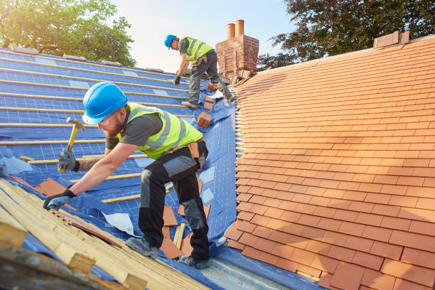 Two men are collaborating on a roof in Marietta, GA, using hammers to secure materials during their professional roofing work.
