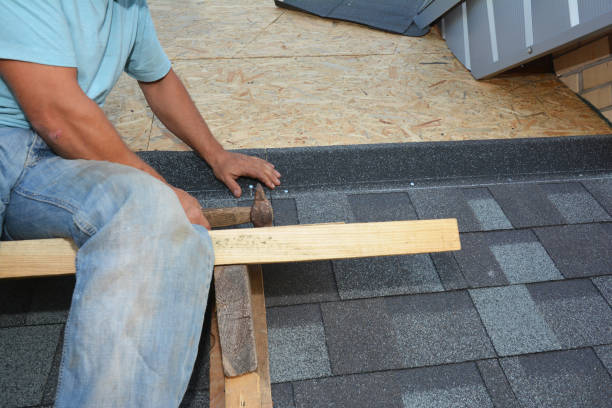 A man is using a hammer to work on a roof, demonstrating construction skills and focus on his task for Affordable Roofing of Atlanta.
