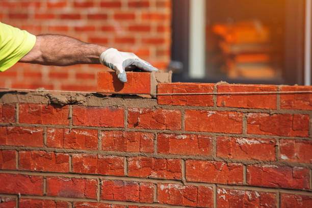 A skilled mason constructs a brick wall in Douglasville, Georgia Masonry, carefully placing each brick for a strong and durable structure.