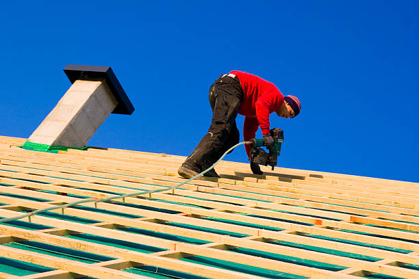 A man is using a ladder to work on a roof, demonstrating waterproofing services in Atlanta during construction or maintenance activities.