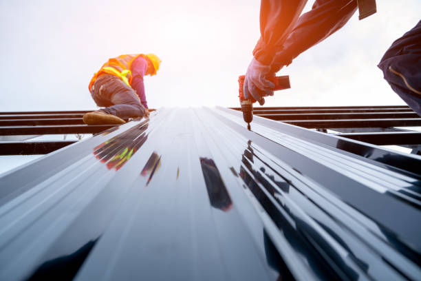 Two men repairing a metal roof under a bright sun, representing a metal roof repair company at work.