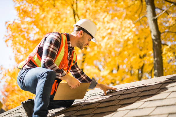 A man in a hard hat and safety vest repairs a roof, showcasing professional roof repairing services.