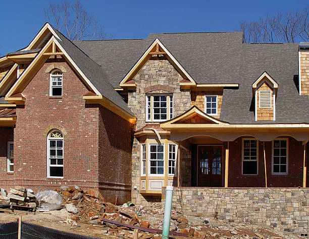 men are engaged in roofing work on a flat metal roof in Atlanta, showcasing their expertise in home improvement.