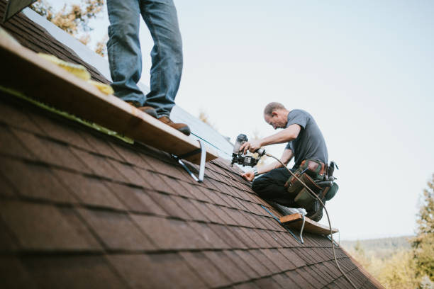  A man in a hard hat and safety vest repairs a roof, showcasing professional roof repairing services.
