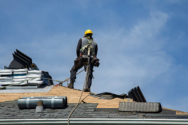 A worker in a hard hat and safety vest is engaged in roof repairs, highlighting roof repairing services.