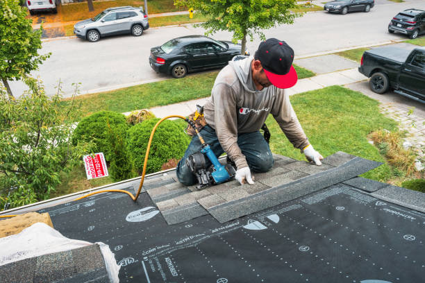 A man wearing a hard hat and safety vest works on a roof, representing professional roof repair services.