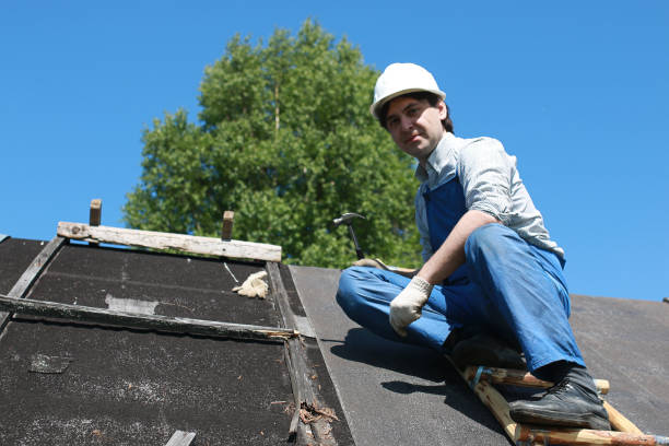 A man uses a nail gun to install shingles on a roof for an affordable roofing company.
