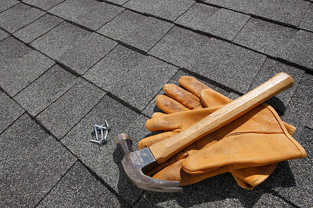 A man shoveling materials on a roof, illustrating the work of an affordable roofing company.