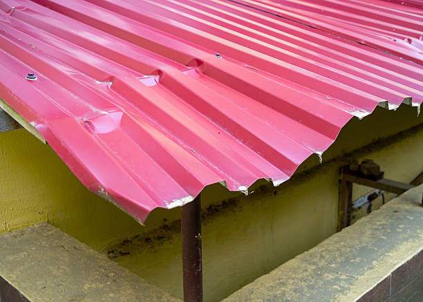  A red building with a metal roof and a single window, showcasing a modern architectural design.